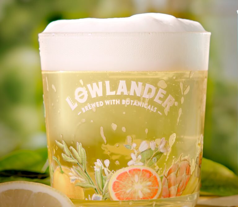 Lowlander packshot bierglas met bier en schuimkraag, achtergrond groene kas.