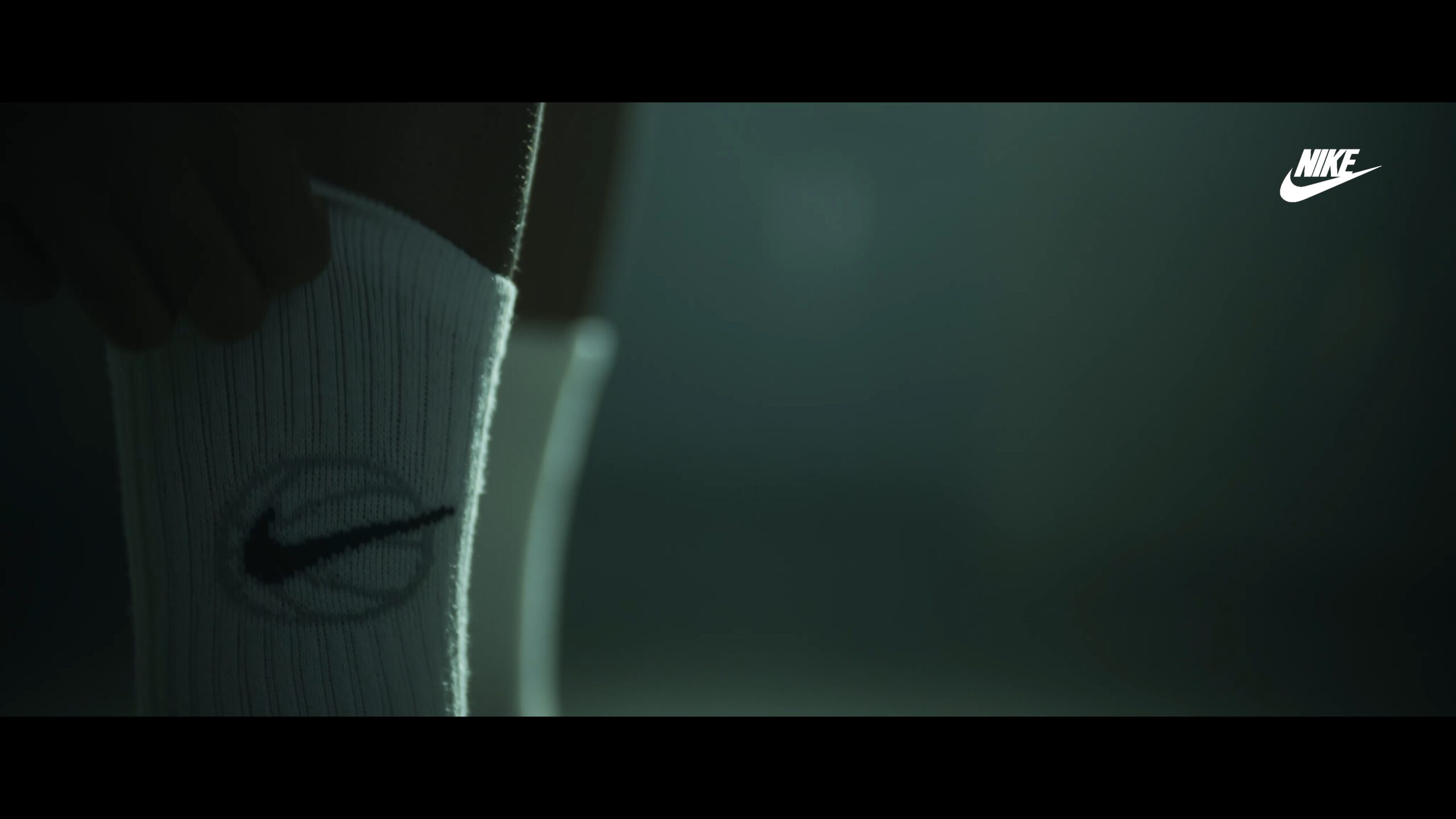 Still van promotiefilm van voetballer die sokken van Nike strak aantrekt