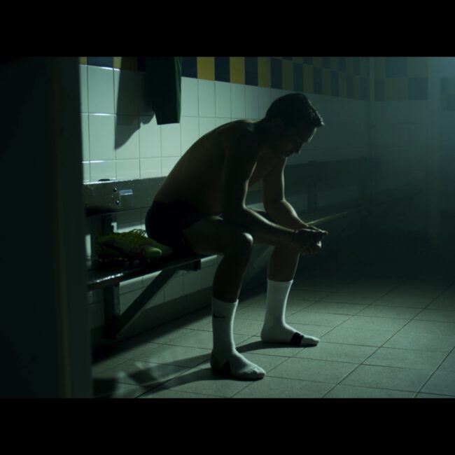 Voetballer in kleedkamer, dark en moody, promotiefilm Nike.
